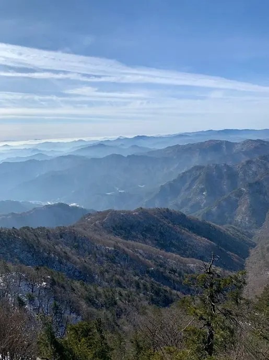 산 아래로 펼쳐진 겨울 산맥과 옅은 운해