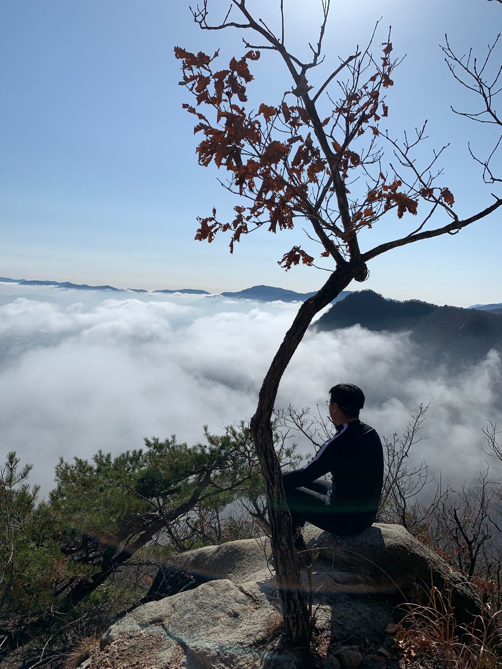 바위에 앉아 운해를 내려다보는 등산객