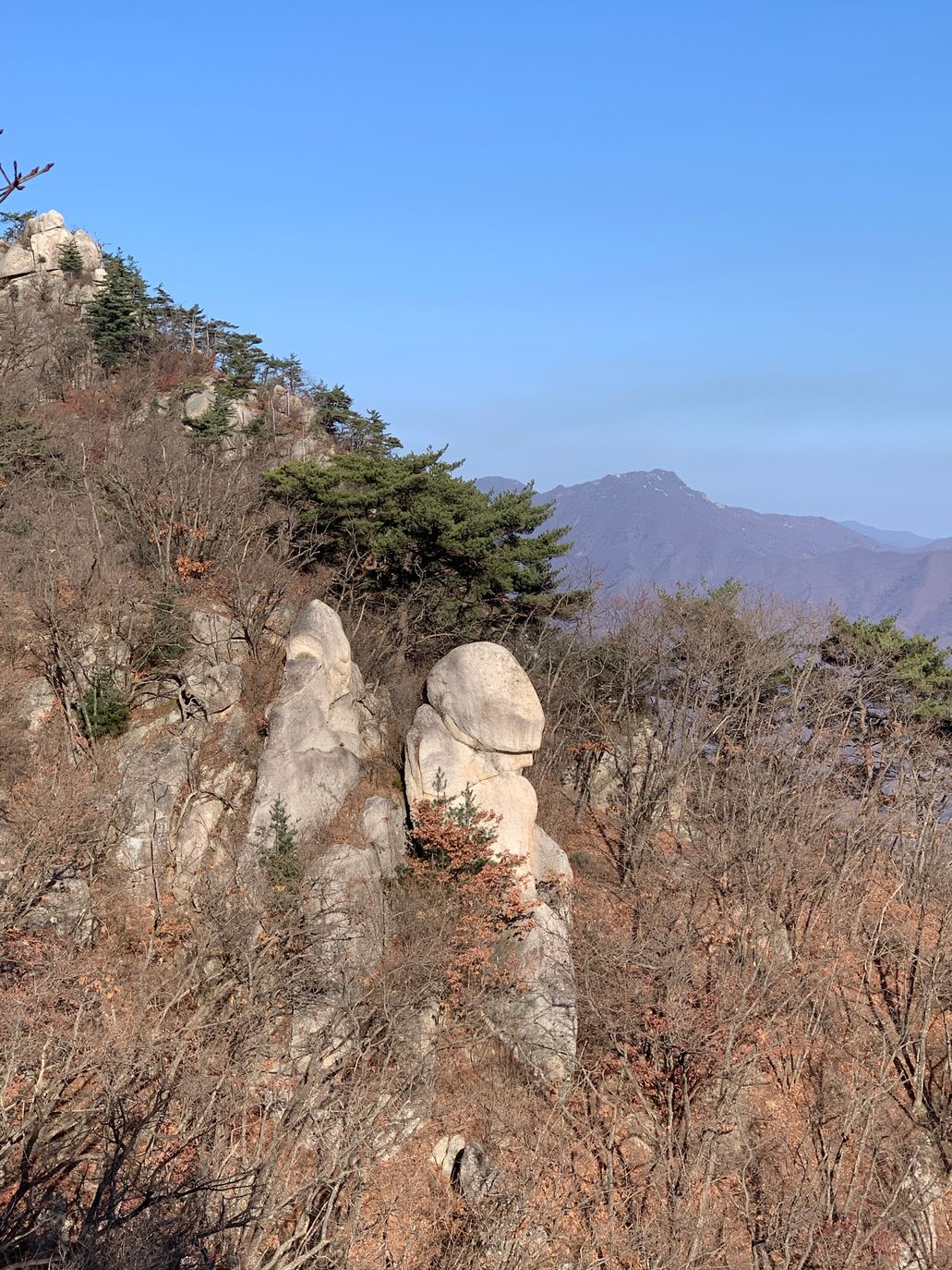 청룡능선의 남근바위 두 개와 뒤로 보이는 먼 산
