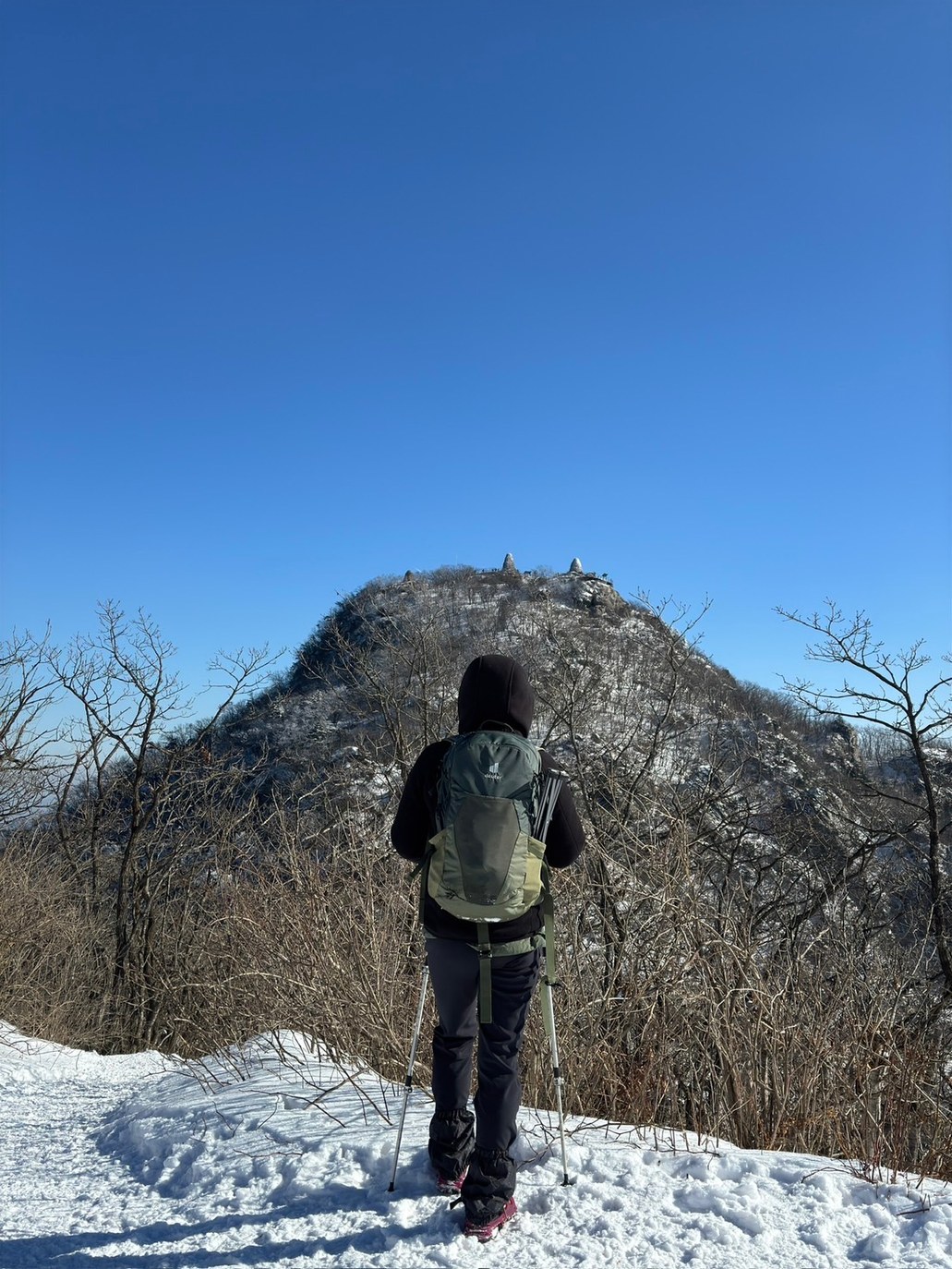 눈 쌓인 능선길에서 비로봉 정상부를 바라보는 등산객
