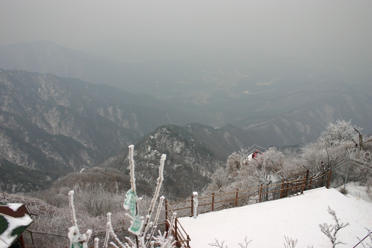 눈 덮인 정상 데크와 상고대 너머로 펼쳐진 산줄기